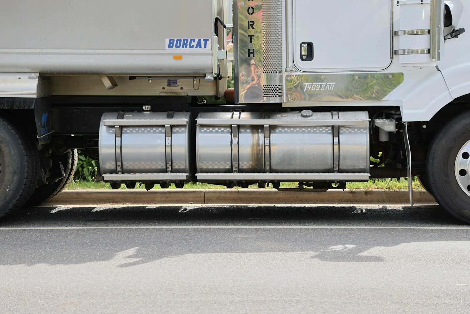 A white semi truck parked on the side of the road